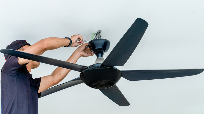 Person installing a modern ceiling fan