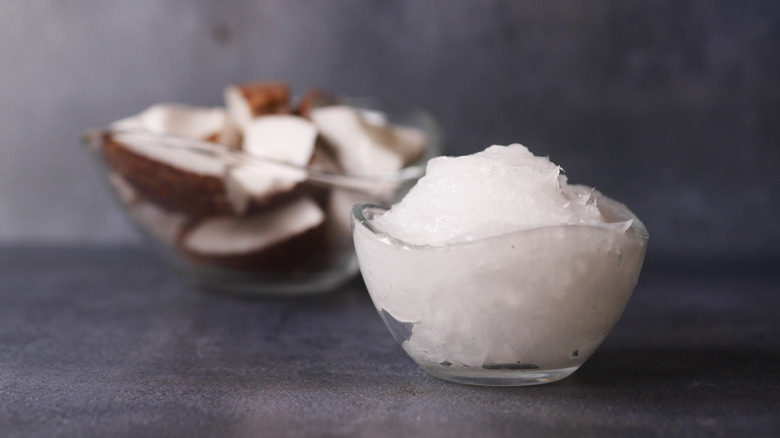 A container of coconut oil against a black background
