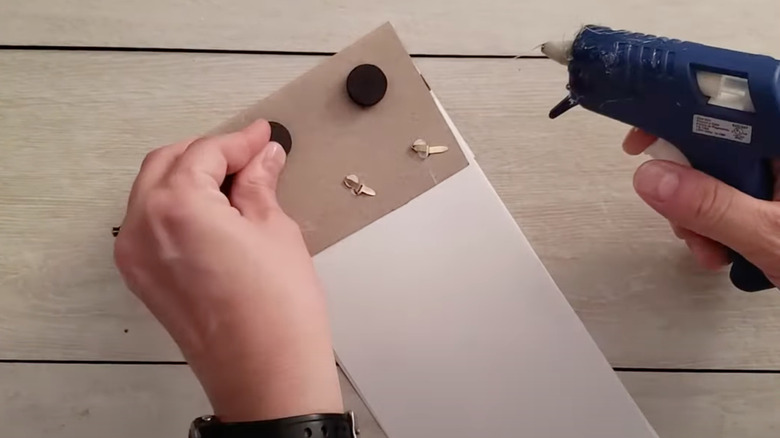 Woman gluing magnets to notebook