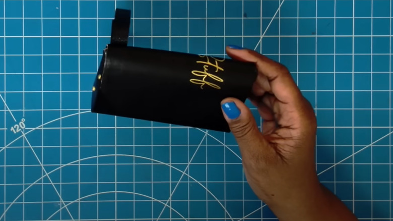 Woman making small leather purse