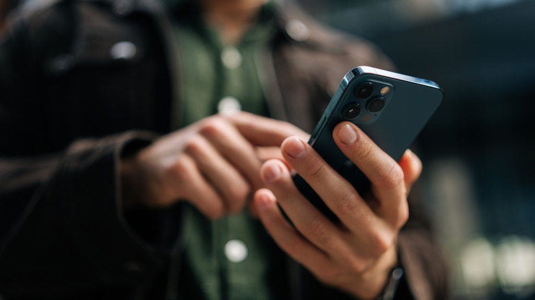 Man in a green shirt using a phone