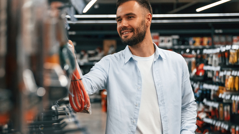 Man looking at cords in hardware store.