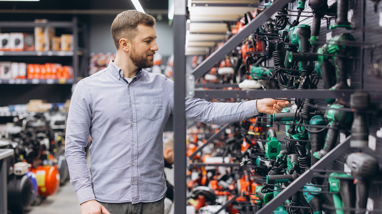 Man shopping for drills in a hardware store