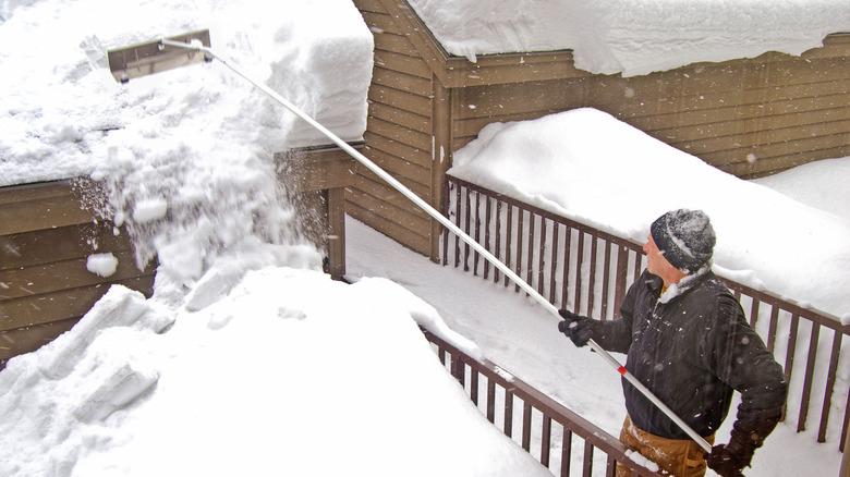 Homeowner using a roof rack to pull snow off of the roof