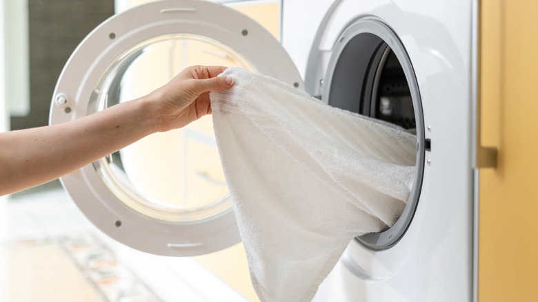 A lady opening a washing machine 