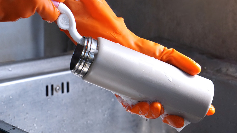 A person cleaning a drinks bottle 