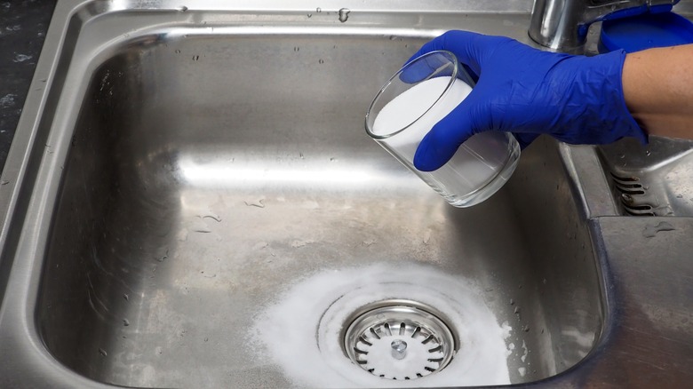 A lady unblocking a drain