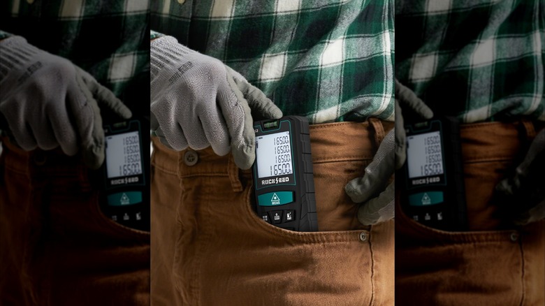 Close-up of a worker stowing RockSeed's Digital Laser Distance Meter in their pocket