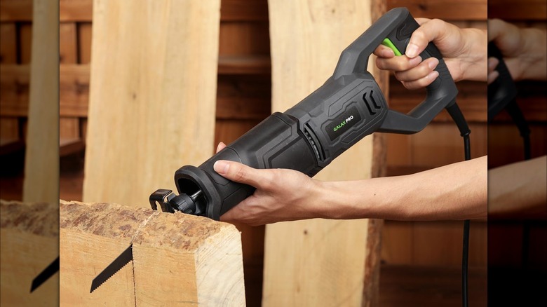A person sawing with Galax Pro's 120V Reciprocating Saw