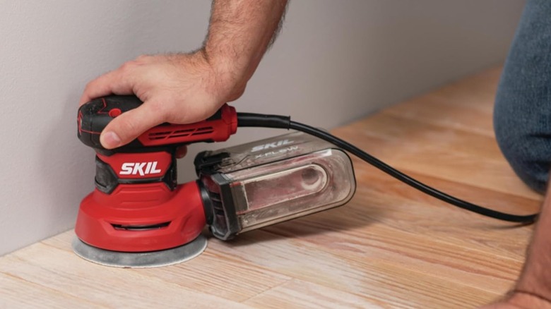 A person using SKIL's 5-inch Random Orbital Sander