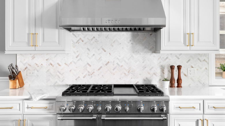 White herringbone backsplash behind a steel stove