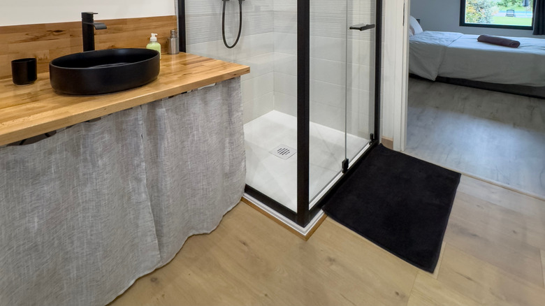 An inside view of the bathroom with the bedroom in the background