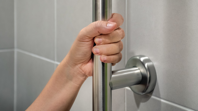 A hand using a grab bar for support