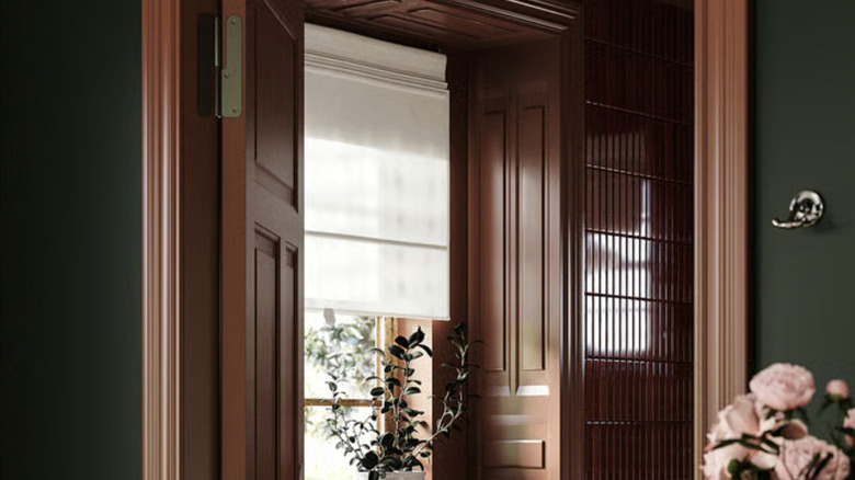 A dark room with wood paneling and shutters with the RINGBLOMMA roman blinds hanging in the window