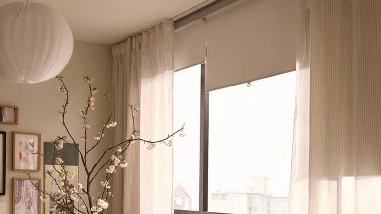 The TRETUR roller blinds from IKEA on tall windows in a beige room