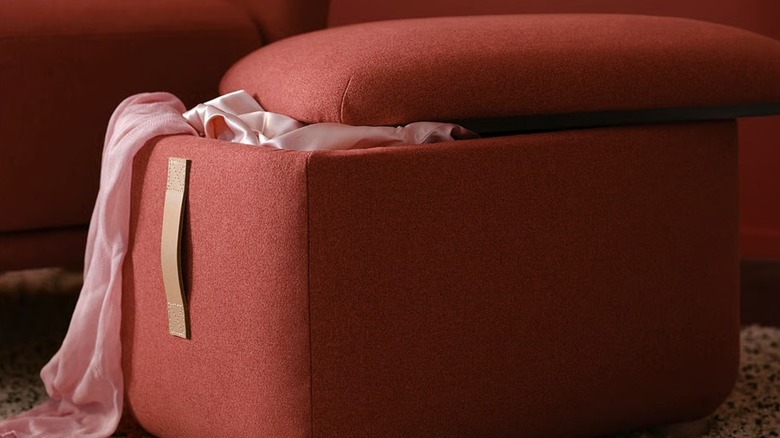 Propped open OSKARSHAMN ottoman with fabric inside