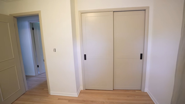 closet door with strips of trim cut from hardboard, rectangular handles, and a fresh coat of paint
