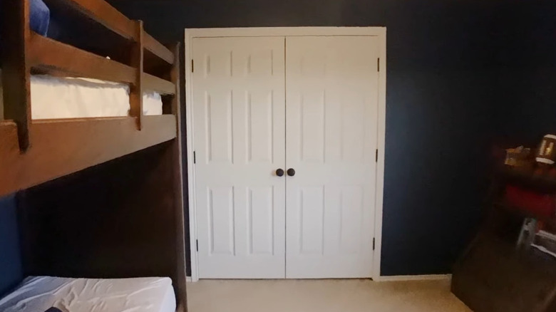two white sliding closet doors have been put on hinges so they open from the center