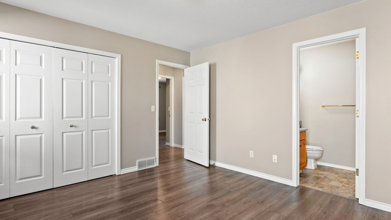plain white closet doors take up most of a wall bedroom