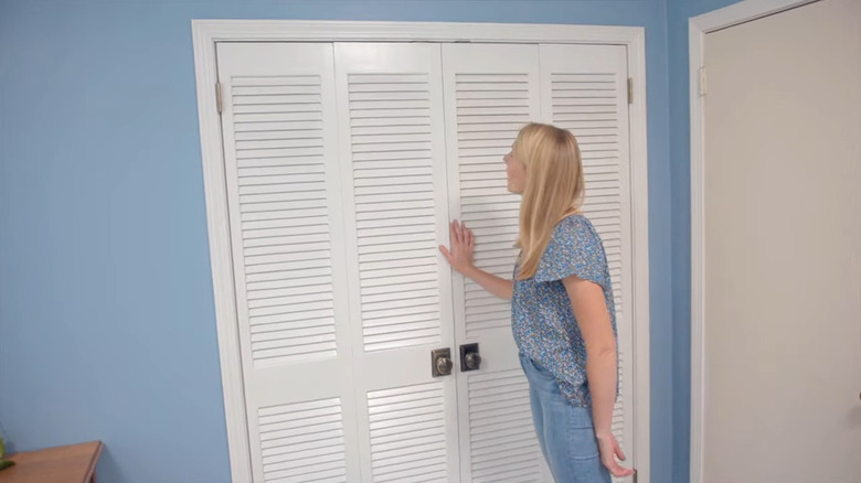 lady in front of white louvered double doors