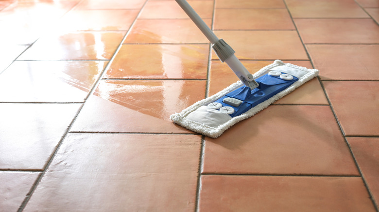 A swifter mop used to wash a tiled floor.