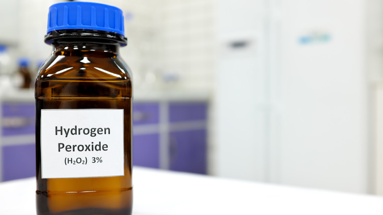 A bottle with a hydrogen peroxide label and a blue cap lid