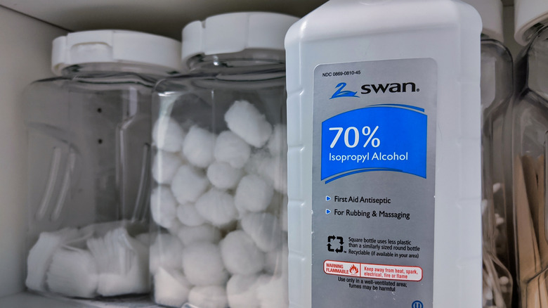A cabinet with a bottle labeled 70 percent isopropyl alcohol.