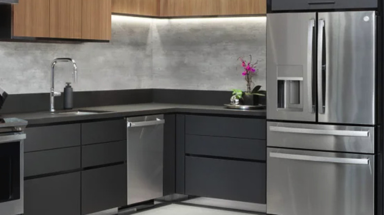 GE Profile fridge in a modern kitchen with dark cabinets and stainless steel appliances