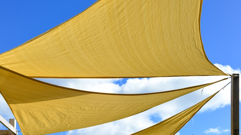 Yellow fabric hung horizontally from a wooden pole