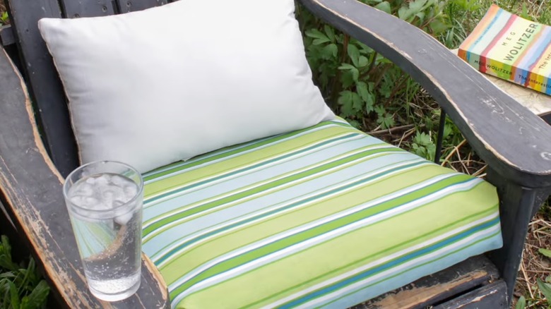 An outdoor wooden chair with DIY cushion on it