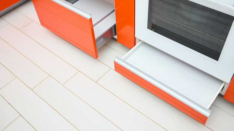 A storage drawer pulled out from beneath an oven