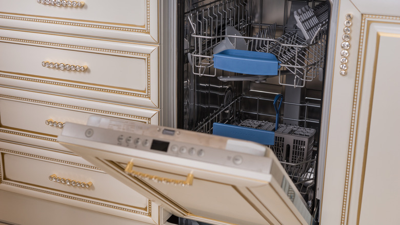 An open dishwasher with a false-front that matches the rest of the cabinet doors