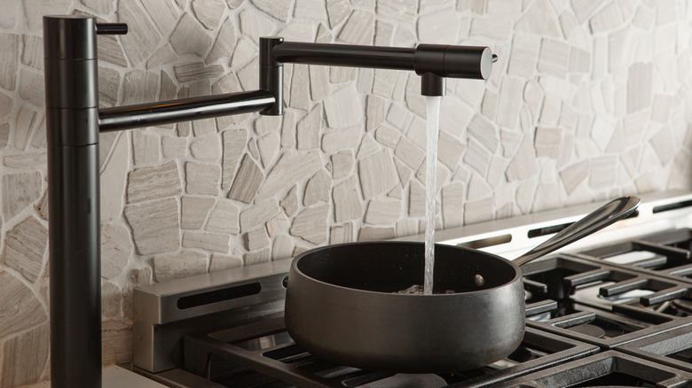 An over-the-stove faucet filling a pot