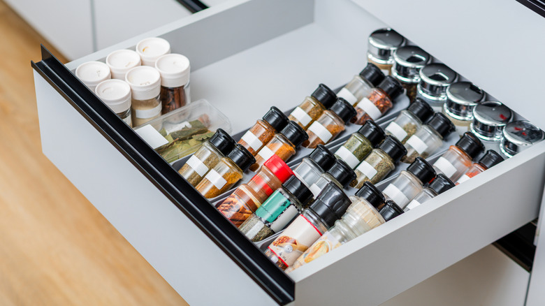 An organized spice drawer filled with various herbs and seasonings