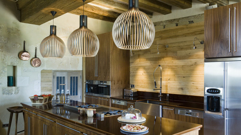A beautiful kitchen with considered lighting, including contemporary pendants and task lighting over the kitchen sink