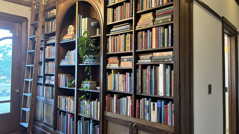 A wall full of open shelves displaying hundreds of books