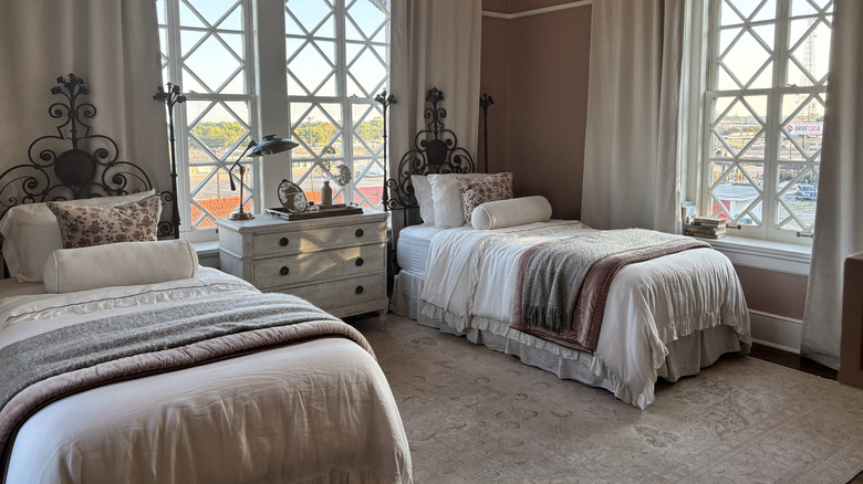A pink room with two matching beds