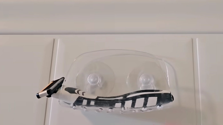 Suction cup sponge holder on shower wall with new razor