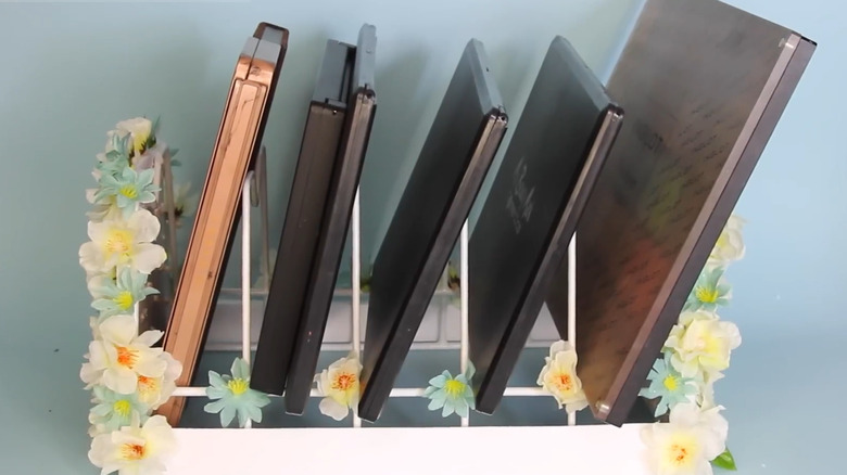 Dollar Tree dish rack stacked with makeup palettes and decorated with flowers