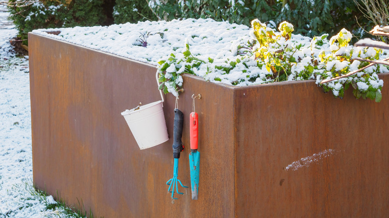 raised garden bed in winter covered in snow
