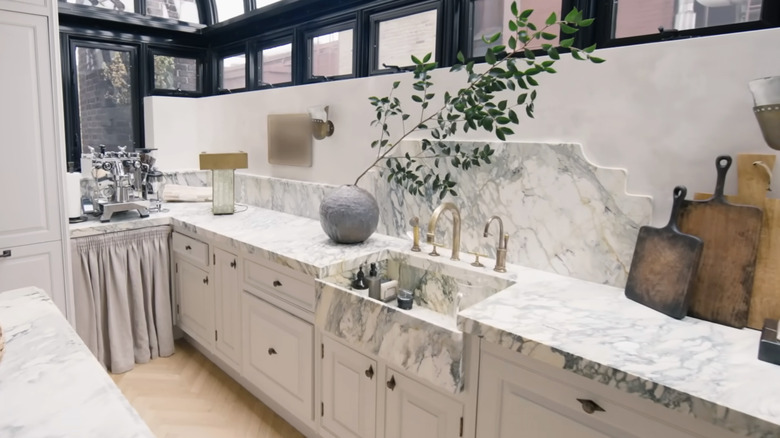 A luxurious kitchen with marble countertops and an apron front sink.
