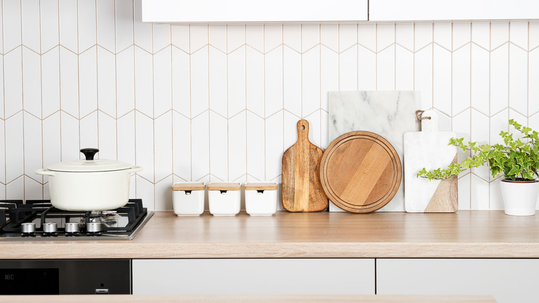 A modern kitchen countertop with cutting boards and jars.