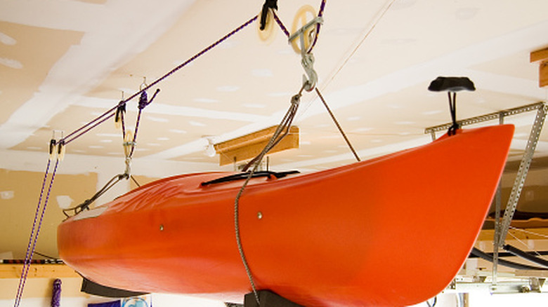 Kayak stored in an overhead organizer in a garage