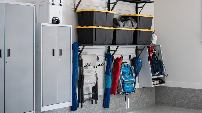 Bins stored on garage storage unit with hanging equipment