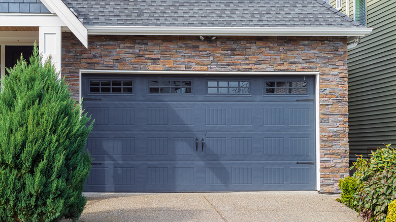 Exterior of garage with brick wall and blue-gray garage door