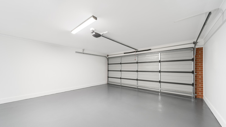 Empty garage with new floors, painted walls, and bright lights