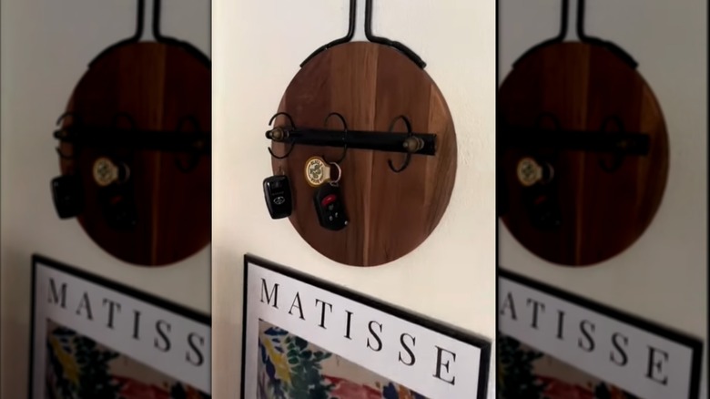 black binder spine on brown hanging board holding keys