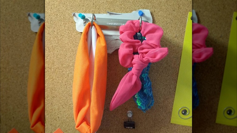pink, orange, and blue headbands and scrunchies hanging on binder spine