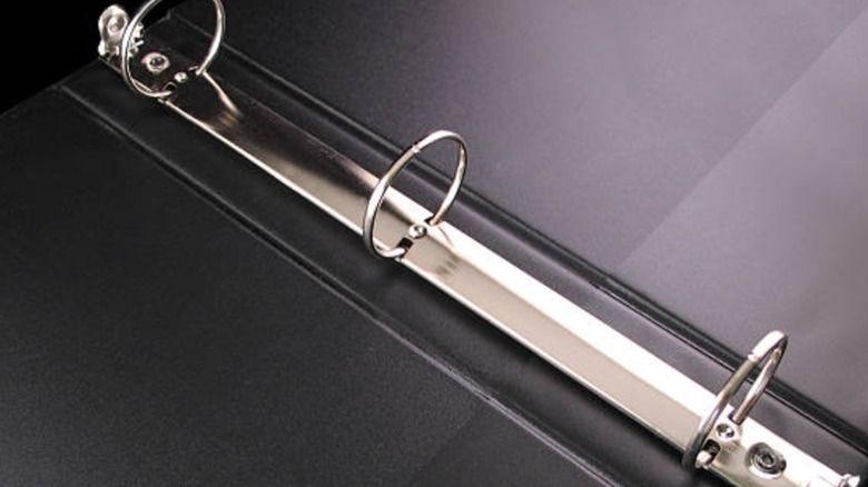close up of black binder with three ring binder spine
