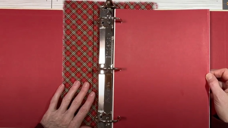someone making a red journal with a binder spine